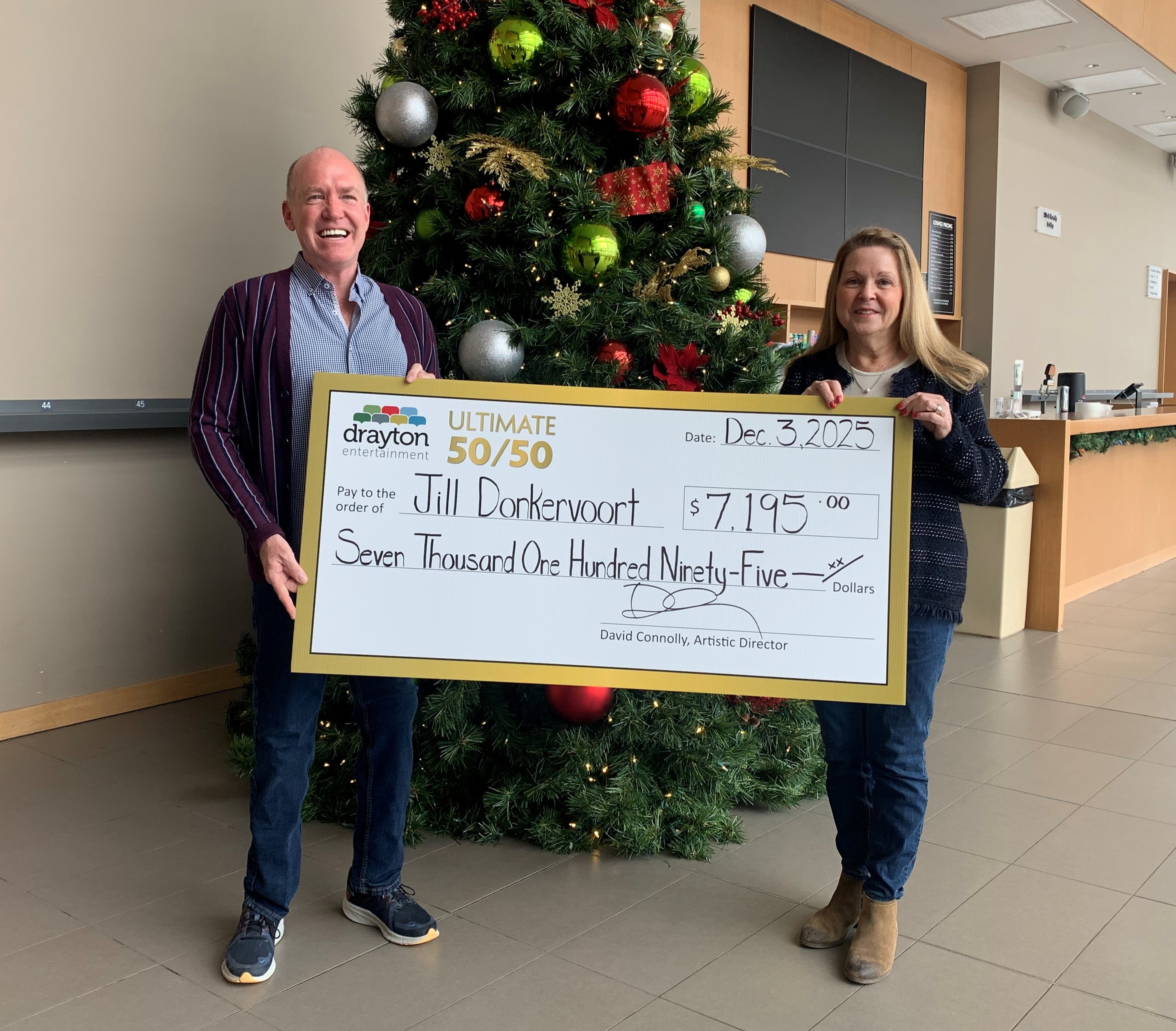 Artistic Director David Connolly presents a cheque for $7,195 to Jill Donkervoort at the Hamilton Family Theatre Cambridge.   